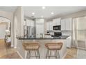 Bright kitchen boasts white cabinetry, stainless steel appliances, a breakfast bar with seating, and tile flooring at 14781 Old Thicket Trce, Winter Garden, FL 34787