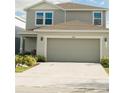 Two-story home with a gray exterior, a two-car garage, and well maintained landscaping at 17148 Cagan Crossings Blvd, Clermont, FL 34714