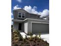 Charming two-story home with a gray exterior, a two-car garage, and well maintained landscaping at 17148 Cagan Crossings Blvd, Clermont, FL 34714