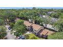 Wide aerial view of a townhouse community surrounded by lush greenery with nearby streets and parked cars at 1748 Foxhall Cir # 1748, Kissimmee, FL 34741