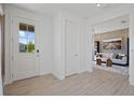 Bright entryway with wood-look tile flooring leading to the living room and a view of the landscaped yard at 2054 Education St, St Cloud, FL 34771