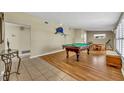 Spacious game room featuring a pool table, wood floors, and natural light from shuttered windows at 2524 Sweetwater Trl, Winter Park, FL 32789