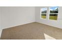 Clean bedroom showcasing plush carpeting and two large windows with natural light at 3071 Sunset Hills Rd, Winter Haven, FL 33881