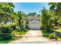 Traditional two-story gray house with mature trees and landscaping plus a two-car garage at 334 N Shadowbay Blvd, Longwood, FL 32779
