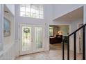 Elegant foyer with decorative glass doors, tile flooring, and soaring ceilings at 334 N Shadowbay Blvd, Longwood, FL 32779