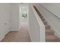 Hallway with staircase that leads to the upper floor and features neutral colored carpet at 3435 Vesara Dr, Davenport, FL 33837