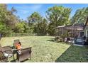 Large backyard with a screened-in patio, offering ample space for outdoor activities and relaxation at 3451 Players Point Loop, Apopka, FL 32712