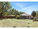Spacious backyard featuring a screened-in patio, mature trees, and a well-manicured lawn at 3451 Players Point Loop, Apopka, FL 32712