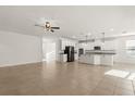 Bright, open-concept kitchen and living area with tile flooring, white cabinets, and a large island at 3925 Green Sabal Dr, Orlando, FL 32824