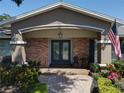 Inviting front porch with brick accents, decorative sconces, and a stylish double door entry at 5127 Leeward Way, Orlando, FL 32809