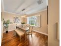 Elegant dining room featuring hardwood floors, natural light, and a modern chandelier at 5262 Baskin St, Orlando, FL 32814