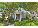 Inviting two-story home showcasing a columned porch, balcony, and lush landscaping at 5262 Baskin St, Orlando, FL 32814