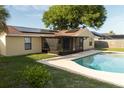 Backyard view of the swimming pool and screened-in lanai of this single Gathering home at 5547 Garden Grove Cir, Winter Park, FL 32792