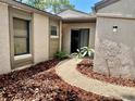Charming courtyard entrance features a curved walkway and lush landscaping at 650 Woodridge Drive, Fern Park, FL 32730