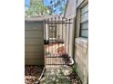 Wrought iron gate leading to landscaped courtyard offers privacy and architectural detail at 650 Woodridge Drive, Fern Park, FL 32730