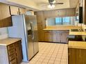 Functional kitchen with stainless steel refrigerator, tile floor and ample cabinet storage at 650 Woodridge Drive, Fern Park, FL 32730