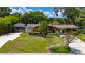 Well-maintained brick home with a screened-in porch, mature landscaping, and a covered carport at 7 Westchester Dr, Kissimmee, FL 34744