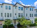 Charming townhome featuring a stylish exterior, lush greenery, and a welcoming entrance with a lovely wreath at 8460 Sperry St, Orlando, FL 32827