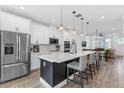 Bright kitchen boasts an island with bar seating, stainless appliances, and an open layout to the dining and living areas at 8460 Sperry St, Orlando, FL 32827