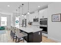 Modern kitchen featuring a large center island with pendant lighting, sleek stainless steel appliances, and white cabinets at 8460 Sperry St, Orlando, FL 32827