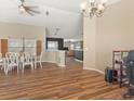 Open-concept dining area with wood floors, connected to the living room and kitchen creating a versatile living space at 10247 Mason Loop, Clermont, FL 34711