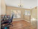 Bright living area featuring wood floors, large window, and a chandelier-style light fixture, creating a welcoming and airy space at 10247 Mason Loop, Clermont, FL 34711