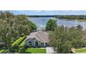 Aerial view of a well-maintained home surrounded by mature trees with lake views providing a private backyard at 1113 Hawthorne Cove Dr, Ocoee, FL 34761