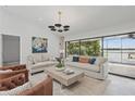 Bright living room with lake view, neutral furniture, modern light fixture, and tile flooring provides an elegant space at 1113 Hawthorne Cove Dr, Ocoee, FL 34761