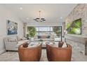 Open living room with lake views, modern chandelier, tile floors, stone fireplace, and comfortable furniture provides ample seating at 1113 Hawthorne Cove Dr, Ocoee, FL 34761