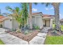 Inviting front entrance featuring a tiled roof, lush landscaping, and a cozy seating area, perfect for enjoying the outdoors at 112 Cordova Ave, Davenport, FL 33897