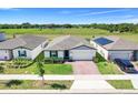 An aerial view of a beautifully landscaped single Gathering home with a brick driveway and green lawn at 1127 Foreshore Ln, Haines City, FL 33844