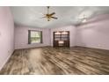 Bright, expansive living room featuring wood laminate flooring and a ceiling fan at 11811 Scarecrow Ln, Orlando, FL 32821
