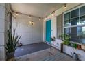 Enclosed front porch with decorative string lights and inviting blue door at 11811 Scarecrow Ln, Orlando, FL 32821