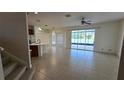 Open-concept living area adjacent to the kitchen with tile flooring and sliding glass door to patio at 12126 Diedra Ct, Orlando, FL 32825