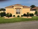 Inviting single-story home featuring manicured lawn, rock landscaping, and a bright, sunny facade at 1221 Santa Cruz Dr, The Villages, FL 32162