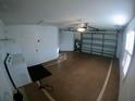 Spacious garage with white walls, painted floors, and an electric garage door at 1221 Santa Cruz Dr, The Villages, FL 32162