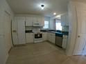 Bright kitchen with white cabinets, appliances, tile floor, and a view of the backyard at 1221 Santa Cruz Dr, The Villages, FL 32162