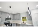 Modern kitchen with gray cabinetry, stainless steel appliances, and quartz countertops at 13525 Se 100Th Ave, Belleview, FL 34420