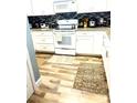 Well-lit kitchen featuring white cabinetry, modern appliances, hardwood floors, and neutral decor at 14033 Turning Leaf Dr, Orlando, FL 32828