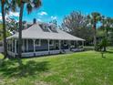Beautiful home with a full front porch is framed by palm trees and green grass at 141 S Central Ave, Apopka, FL 32703