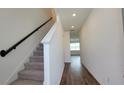 Bright hallway features recessed lighting, a staircase with modern railing, and wood-look flooring at 1429 Discovery St, Davenport, FL 33896