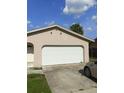 Side view of a home showcasing the garage and driveway. Lawn needs some work at 2087 Allegheny Ct, Orlando, FL 32818