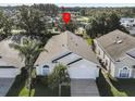 Aerial view of a single-story home with neutral paint, a two-car garage, and mature landscaping at 2115 Morning Star Drive, Clermont, FL 34714