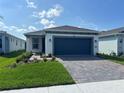 Charming single-Gathering home with a well-manicured lawn and a dark blue two-car garage at 2333 Daisy Tree Rd, St Cloud, FL 34771