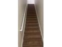 Carpeted stairway leading to upper floors, featuring a handrail and neutral wall paint at 417 Southern Pecan Cir # 201, Winter Garden, FL 34787