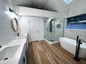 Modern bathroom featuring double vanities, a sleek glass-enclosed shower, and a freestanding bathtub at 460 W Palm Valley Dr, Oviedo, FL 32765