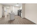 Modern kitchen featuring white cabinetry, stainless steel appliances, and hardwood floors at 5447 Vineland Rd # 1308, Orlando, FL 32811