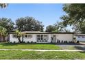 Charming single-story home with fresh white paint, landscaped yard and stylish gray window shutters at 606 Faber Dr, Orlando, FL 32822
