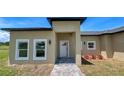Charming home featuring a well-manicured lawn, neutral stucco exterior, and a welcoming front entrance at 6741 Heavitree Dr, Sebring, FL 33876