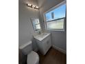 Neat half bathroom featuring a window, vanity with storage, sink and modern light fixture at 6741 Heavitree Dr, Sebring, FL 33876